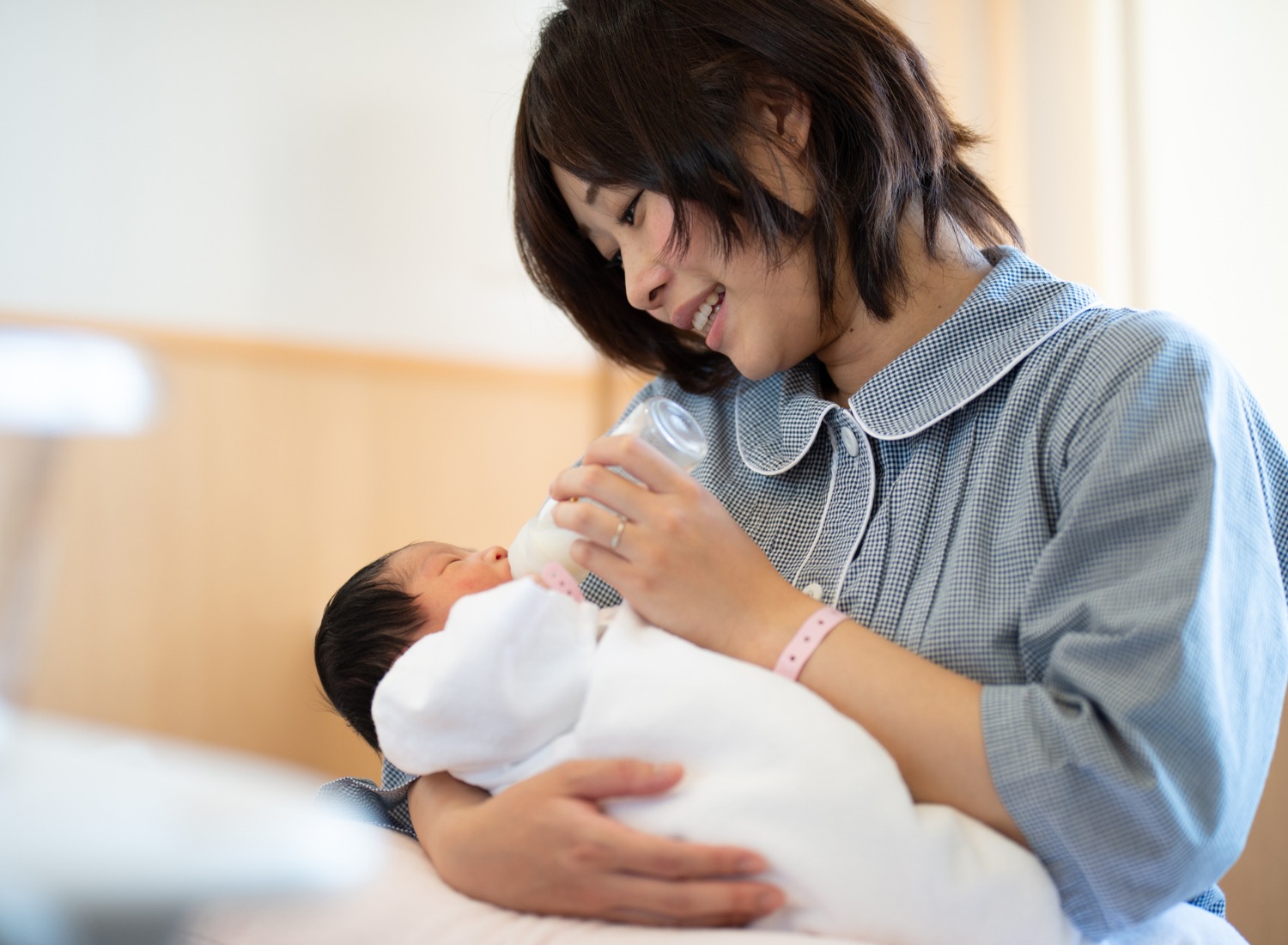 Woman bottle-feeding her newborn baby